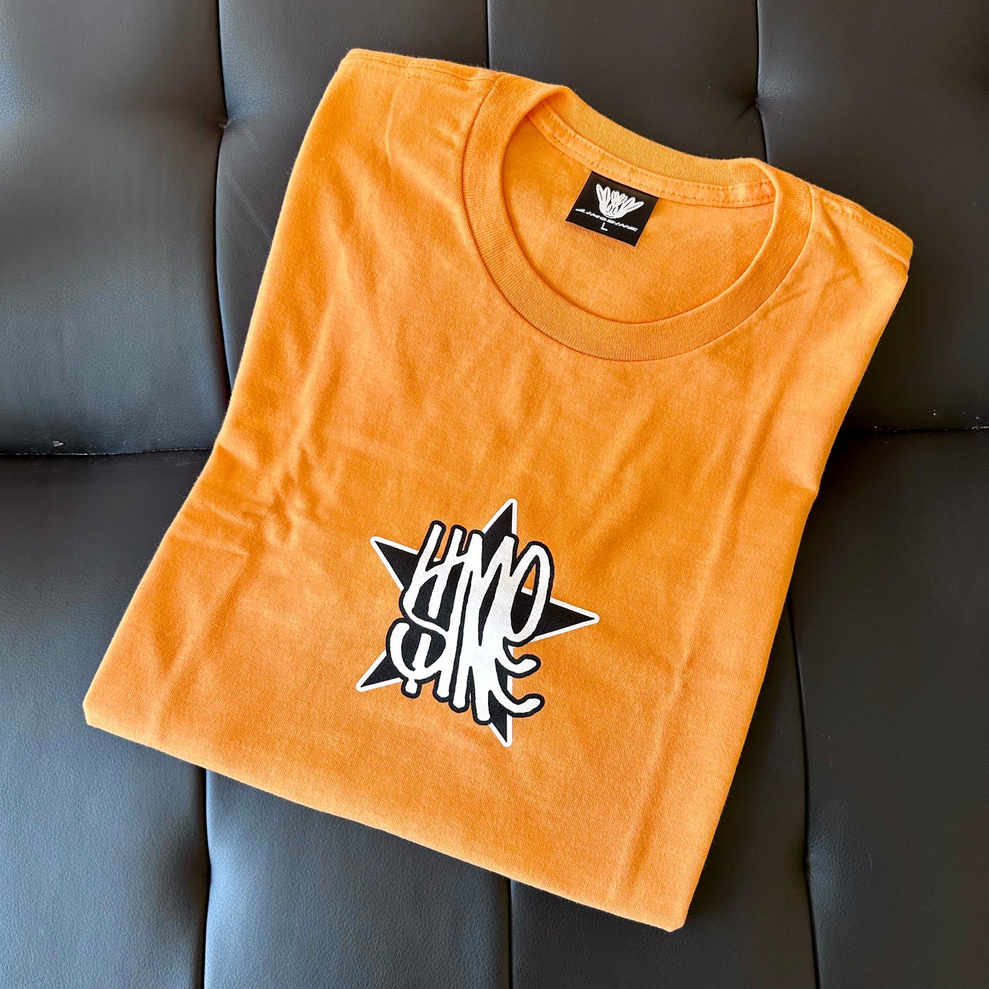 Orange-coral crew-neck graphic tee with star logo print, short sleeves