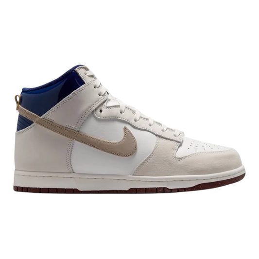Low-angle side view of white high-top sneaker with tan stripe, blue panel, and dark sole