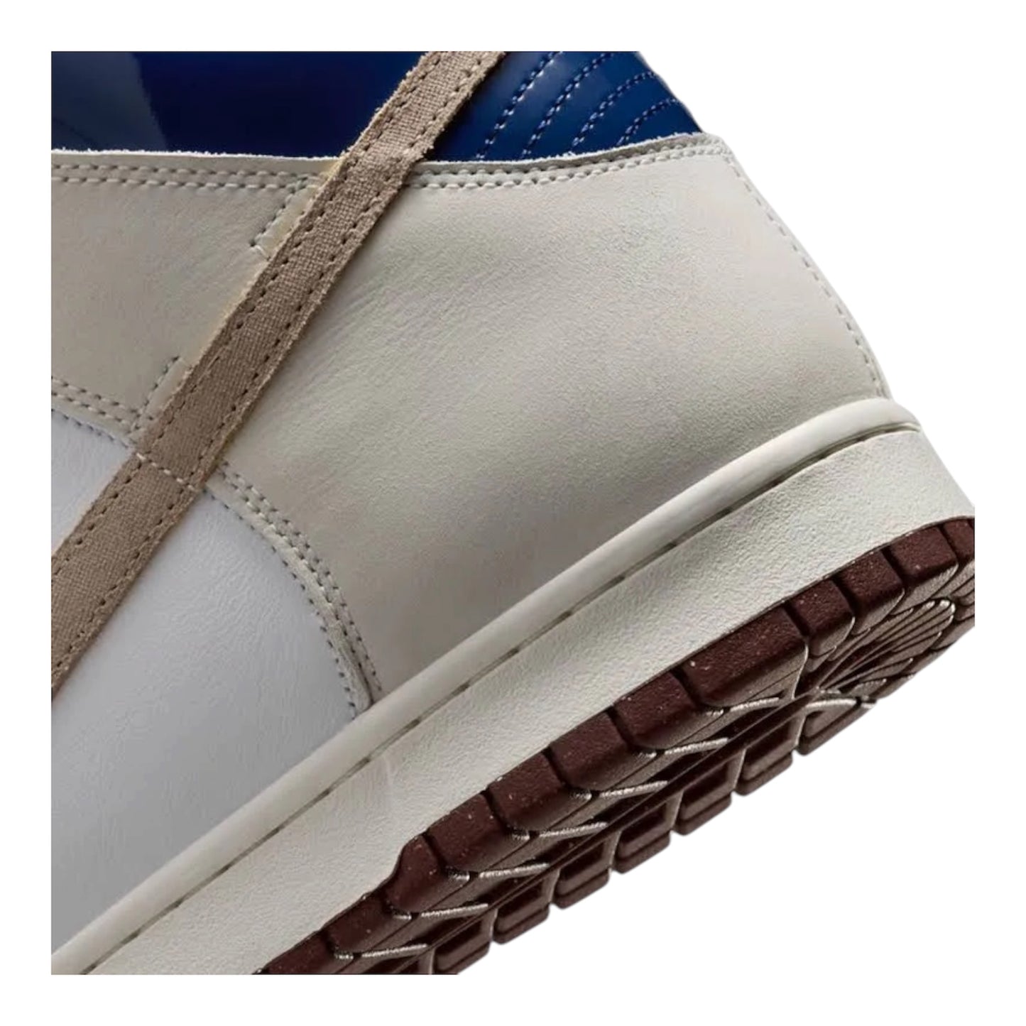 Side view of white high-top sneaker with tan strap and dark brown textured outsole