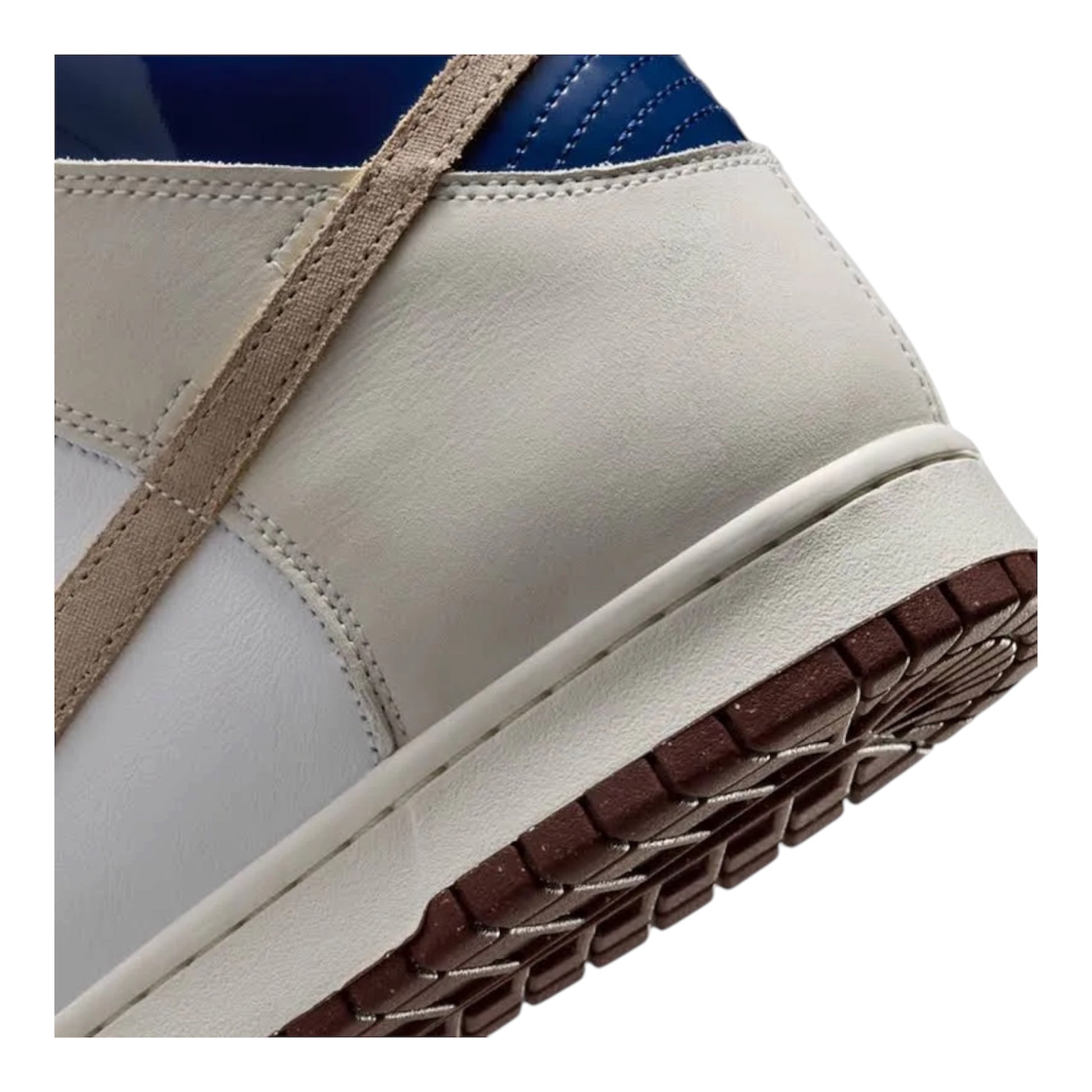 Side view of white high-top sneaker with tan strap and dark brown textured outsole