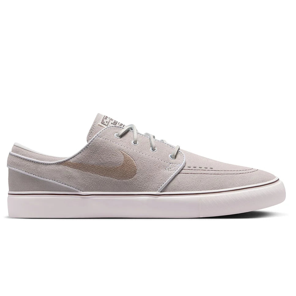 Light gray low-top skate shoes with swoosh logo and lace-up closure, side view